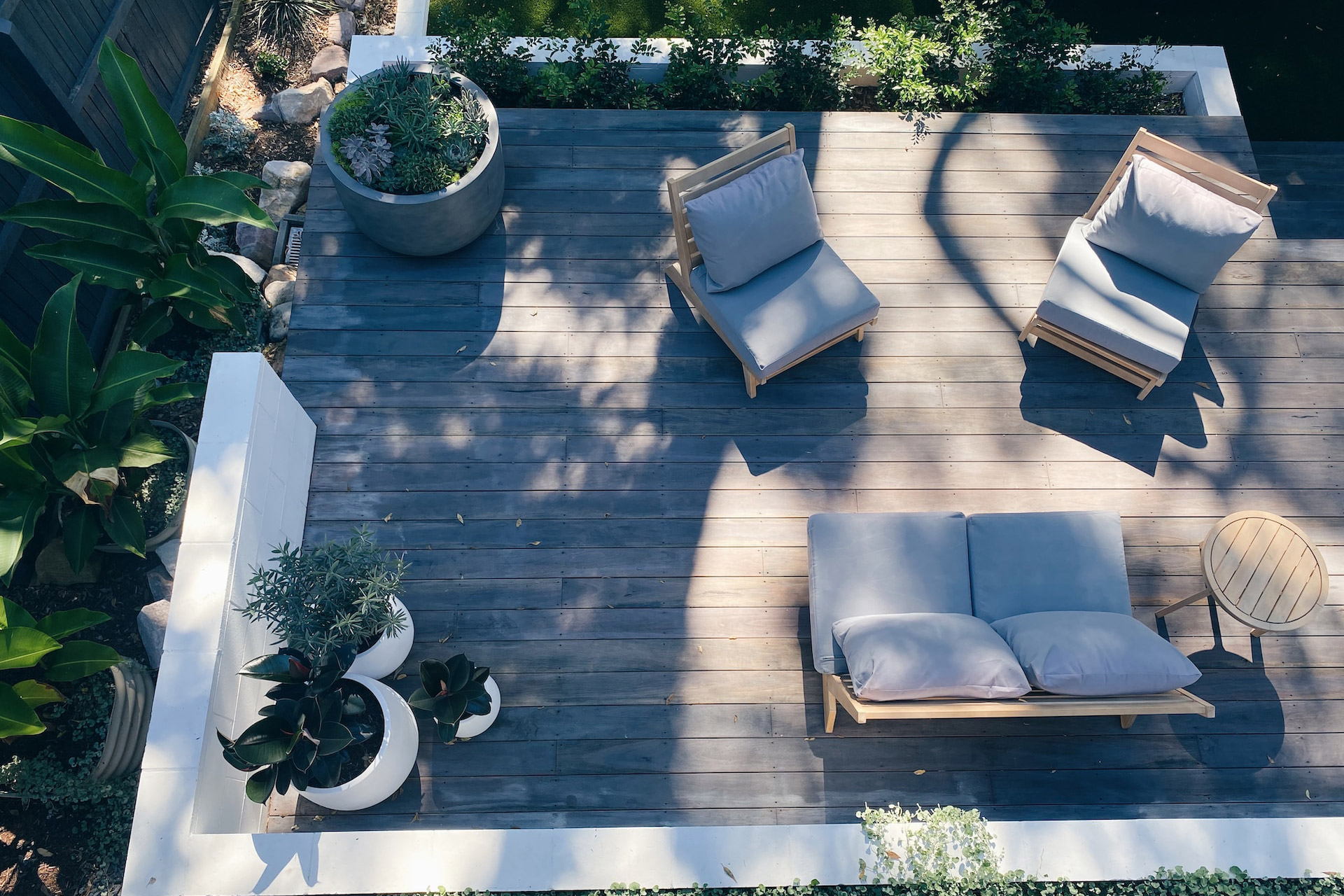A beautifully designed outdoor garden decking area with a table and chairs.