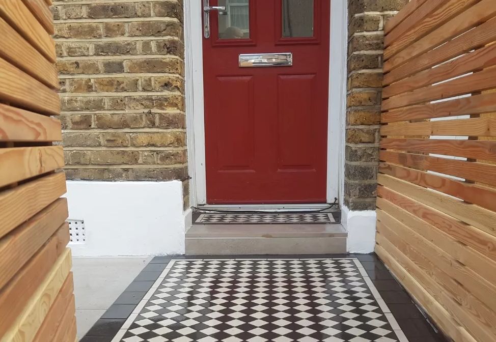 Victorian black and white floor tiles with a modern horizontal fence. An example of the front garden landscaping offered by Green Team Landscaping.