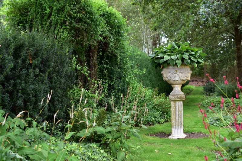 sculpture with plants in it in a long garden